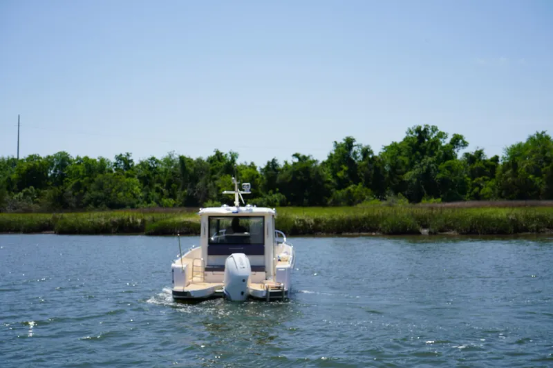 Slide: The Image of 2024 Nimbus Commuter9 C9 boat cruising on a serene river with lush greenery. - 5