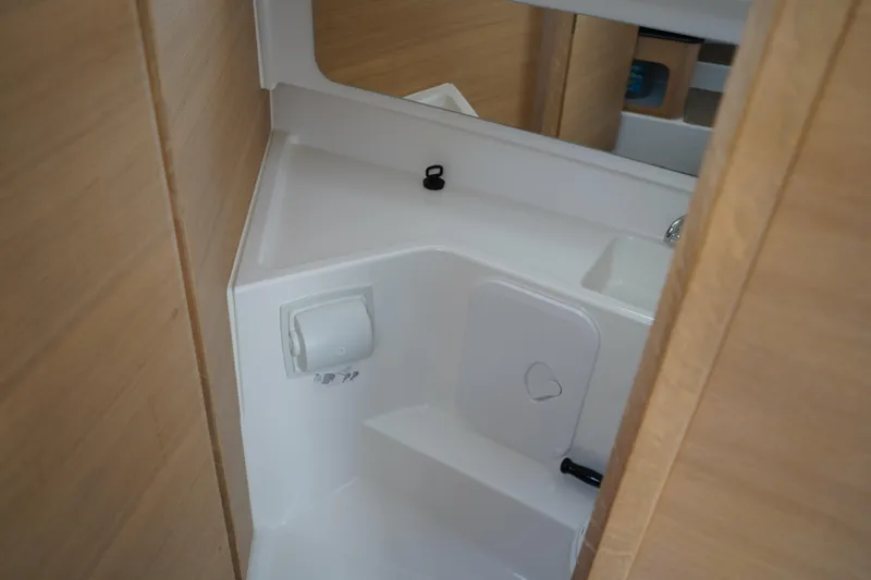 Slide: The Image of 2024 Nimbus Commuter9 C9 boat interior bathroom with wooden accents and compact design. - 40
