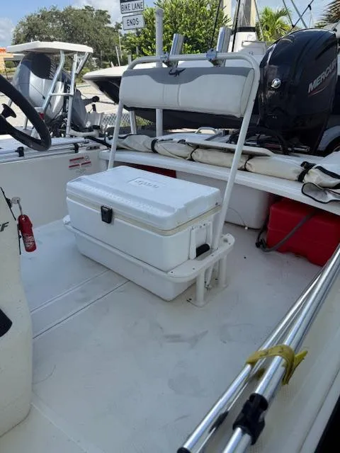 Slide: The Image of 2023 Mako Pro Skiff 17 CC interior with cooler and Mercury outboard motor. - 13