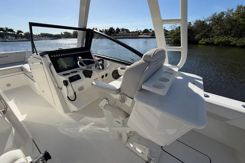 Slide: The Image of 2026 World Cat 265 DC-X boat interior with helm, steering wheel, and seating by the water. - 14