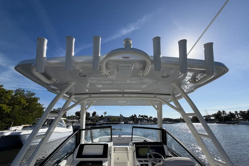 Slide: The Image of 2026 World Cat 265 DC-X boat helm with T-top, on a sunny day by the water. - 16