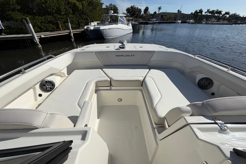 Slide: The Image of 2026 World Cat 265 DC-X boat interior with spacious seating, docked by a serene waterfront. - 20