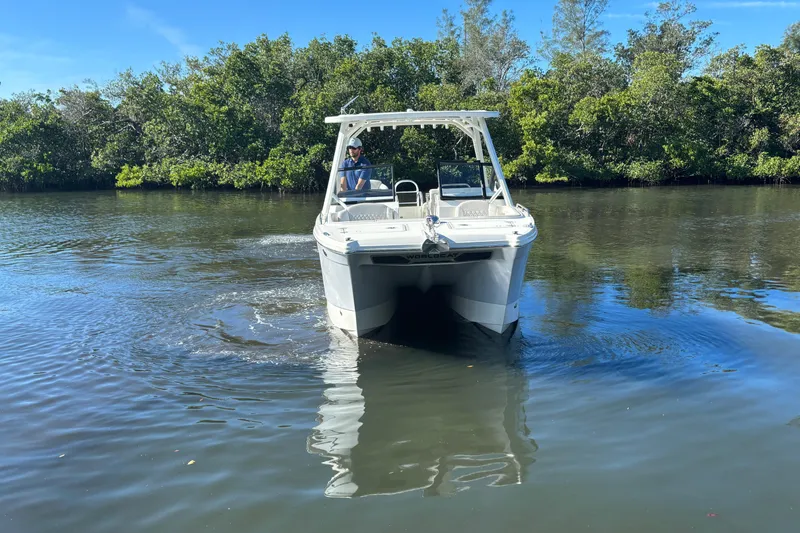 Slide: The Image of 2026 World Cat 265 DC-X boat navigating calm waters with lush greenery background. - 4