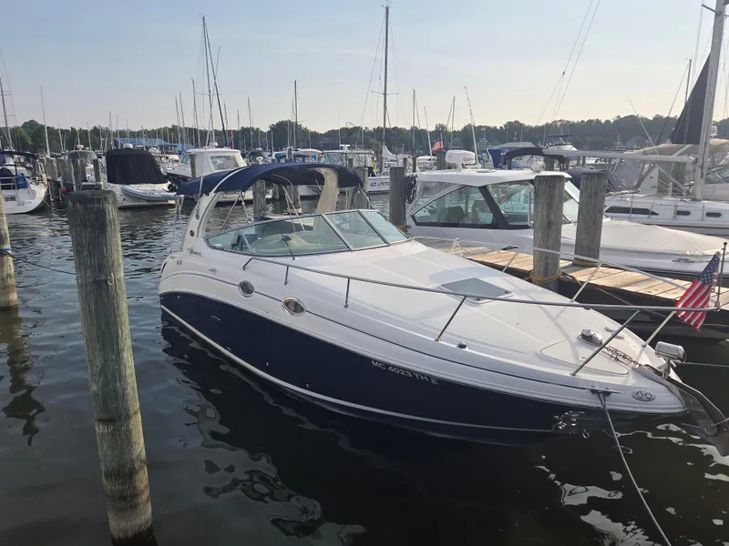 Slide: The Image of 2004 Sea Ray 280 Sundancer docked at marina, surrounded by other boats. - 1