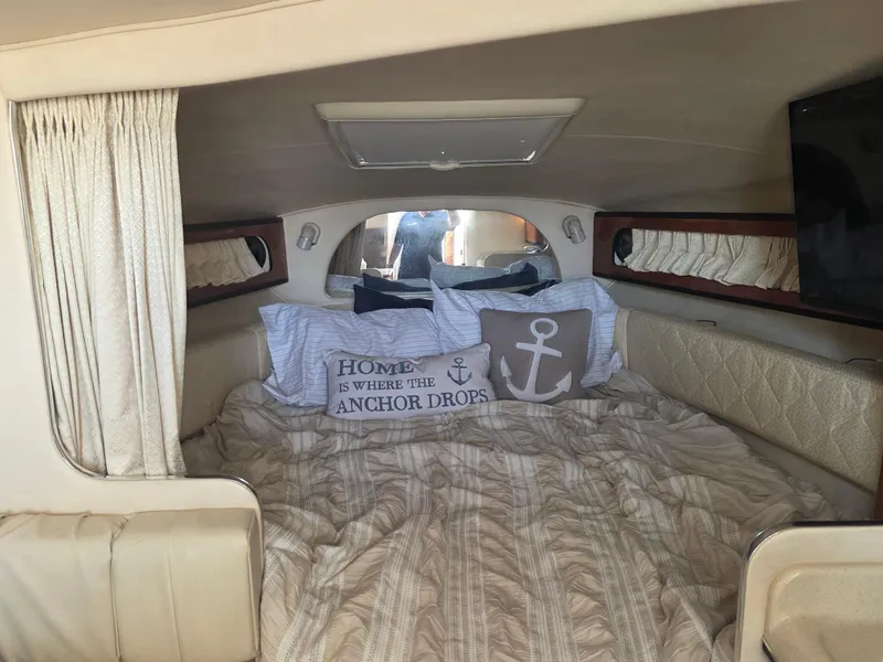Slide: The Image of Cozy cabin interior of 2004 Sea Ray 280 Sundancer with nautical-themed bedding. - 14