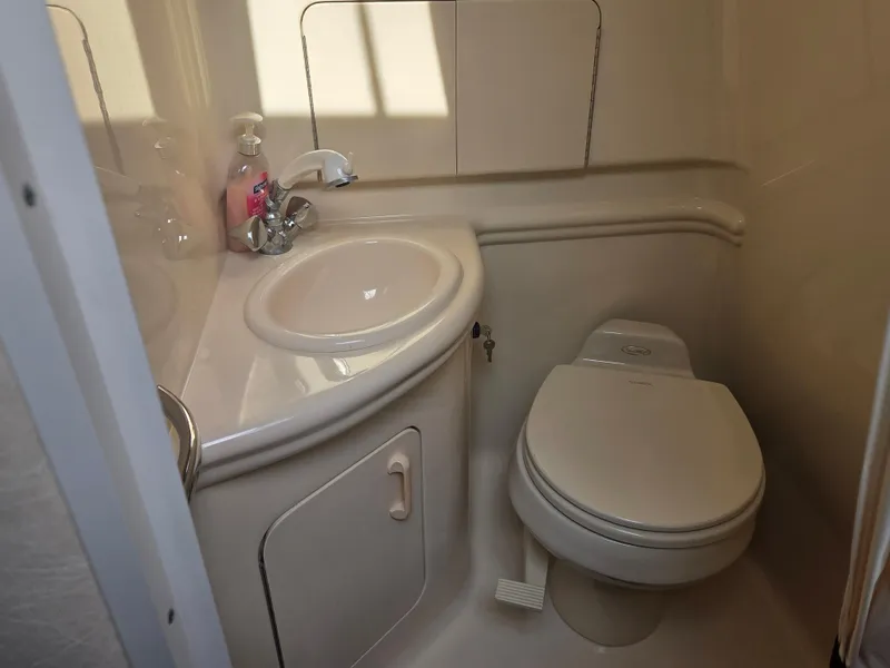 Slide: The Image of Compact bathroom in 2004 Sea Ray 280 Sundancer boat, featuring sink and toilet. - 16