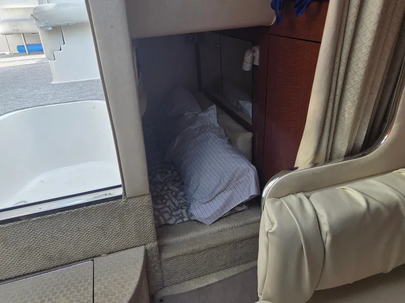 Slide: The Image of 2004 Sea Ray 280 Sundancer cabin interior with cozy sleeping area and striped pillow. - 17