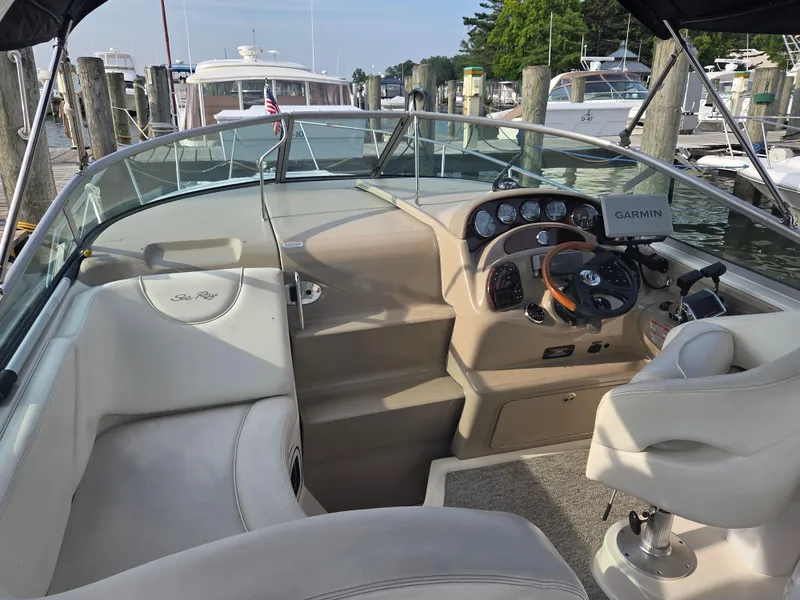 Slide: The Image of 2004 Sea Ray 280 Sundancer cockpit with Garmin navigation, docked at marina. - 2