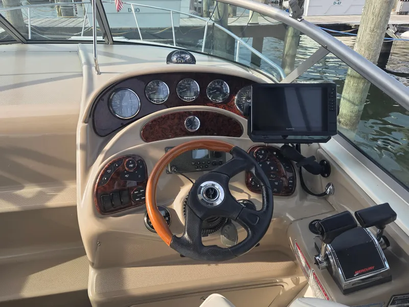 Slide: The Image of 2004 Sea Ray 280 Sundancer helm with gauges, steering wheel, and navigation system. - 3