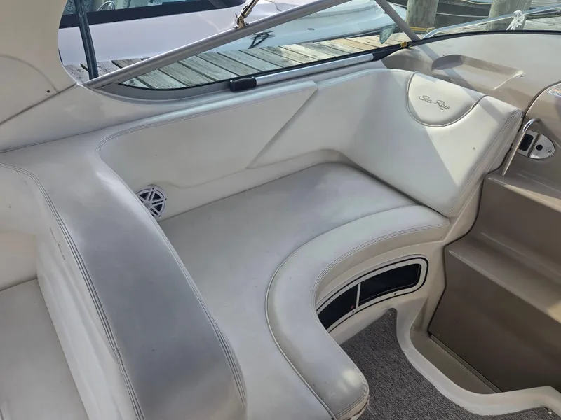Slide: The Image of 2004 Sea Ray 280 Sundancer interior seating with white upholstery and sleek design. - 7