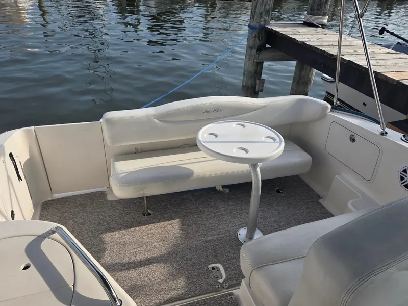 Slide: The Image of 2004 Sea Ray 280 Sundancer boat interior with seating and table by the dock. - 9