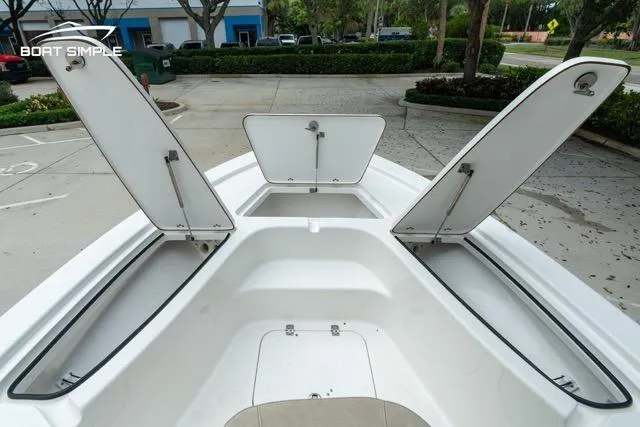Slide: The Image of 2024 Sea Pro 208 Bay boat with open storage compartments, parked outdoors. - 13