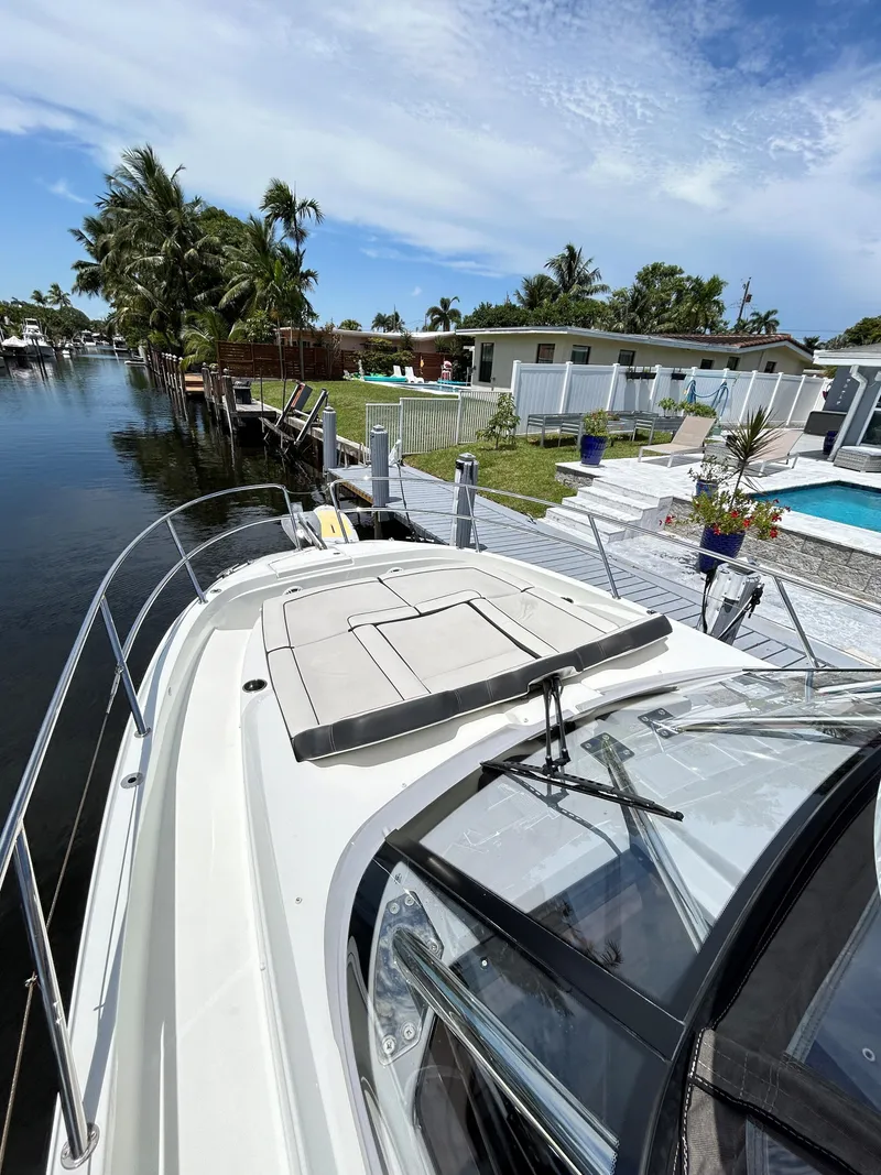 Slide: The Image of 2022 Jeanneau Leader 10.5 WA Series 2 docked by a waterfront home with pool. - 11