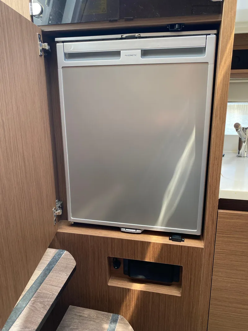 Slide: The Image of Built-in fridge in Jeanneau Leader 10.5 WA Series 2, 2022 model, wooden interior. - 21