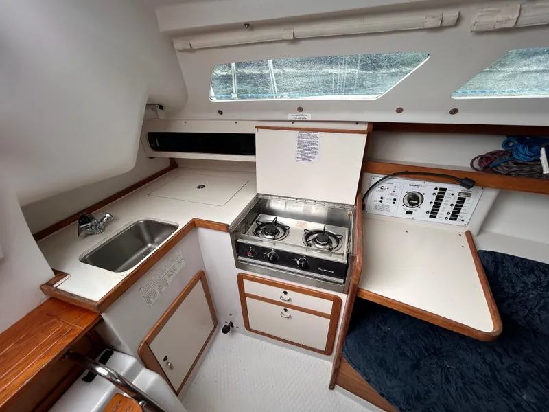 Slide: The Image of Interior of a 1999 Catalina 270 sailboat galley with stove, sink, and control panel. - 14