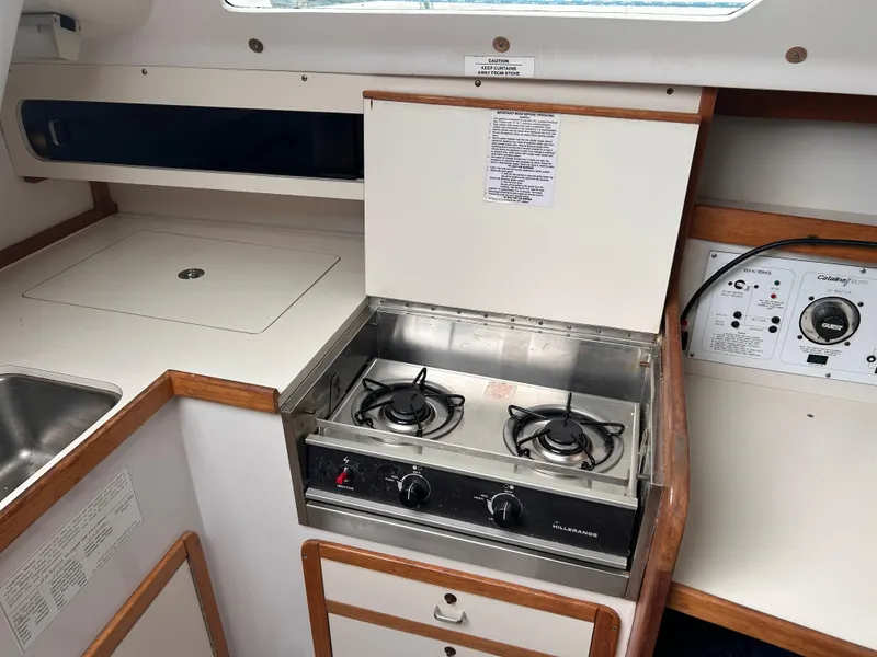 Slide: The Image of 1999 Catalina 270 yacht interior with stove, sink, and control panel. - 17