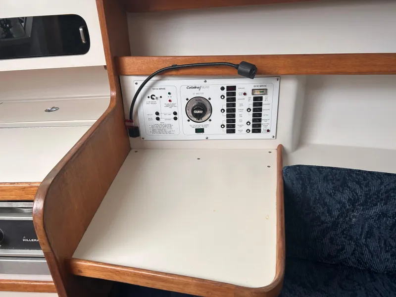 Slide: The Image of Control panel of a 1999 Catalina 270 sailboat with wooden trim and seating area. - 18