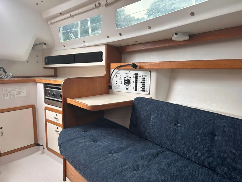 Slide: The Image of Interior of a 1999 Catalina 270 sailboat with blue seating and wooden cabinetry. - 19