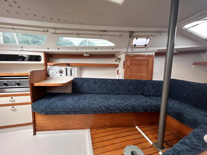 Slide: The Image of Interior of a 1999 Catalina 270 sailboat with blue seating and wooden accents. - 20
