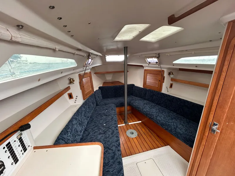 Slide: The Image of Interior of 1999 Catalina 270 sailboat with blue seating and wooden accents. - 21