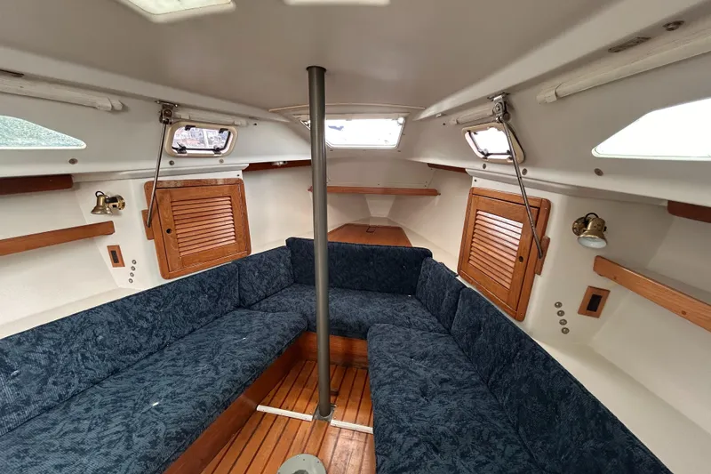 Slide: The Image of Interior of a 1999 Catalina 270 sailboat with blue seating and wooden accents. - 22
