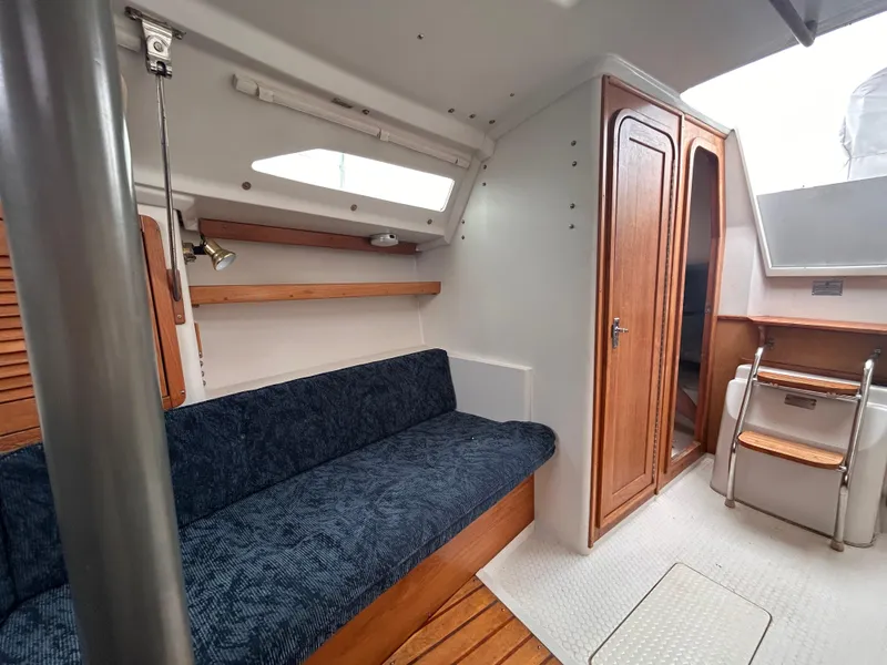 Slide: The Image of Interior of 1999 Catalina 270 sailboat with blue seating and wooden accents. - 24