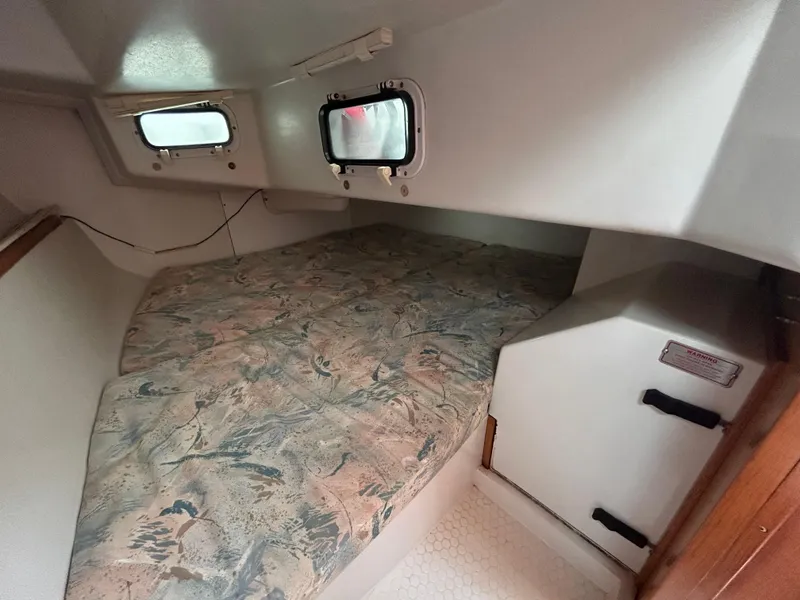 Slide: The Image of Interior cabin of a 1999 Catalina 270 sailboat with patterned bedding. - 29