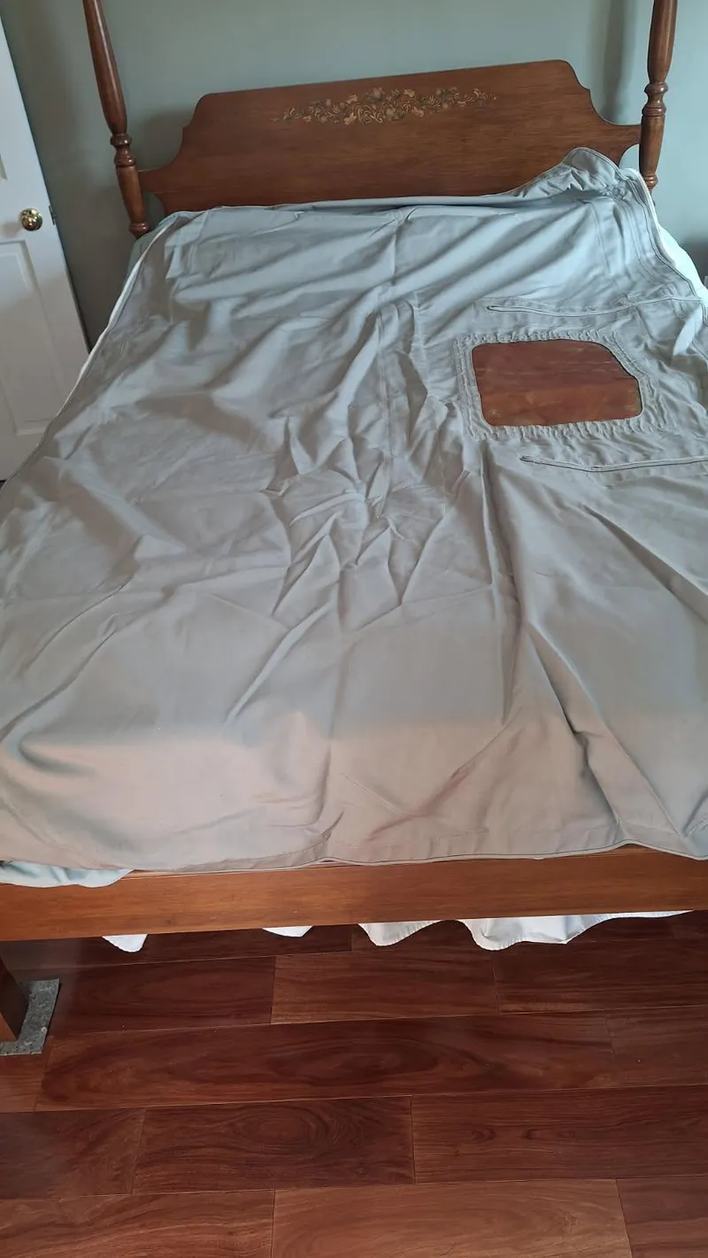 Slide: The Image of Wooden bed with light gray sheet and decorative headboard. - 32