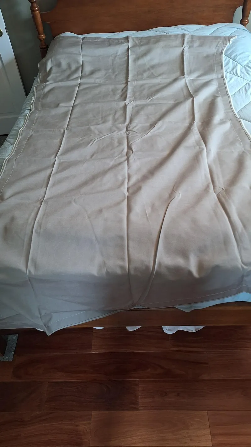 Slide: The Image of Beige blanket on a wooden bed with light blue sheets. - 36