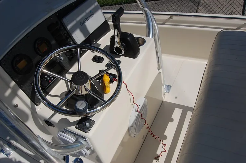Slide: The Image of Control panel of a 2006 Scout 240 boat with steering wheel and Garmin device. - 15