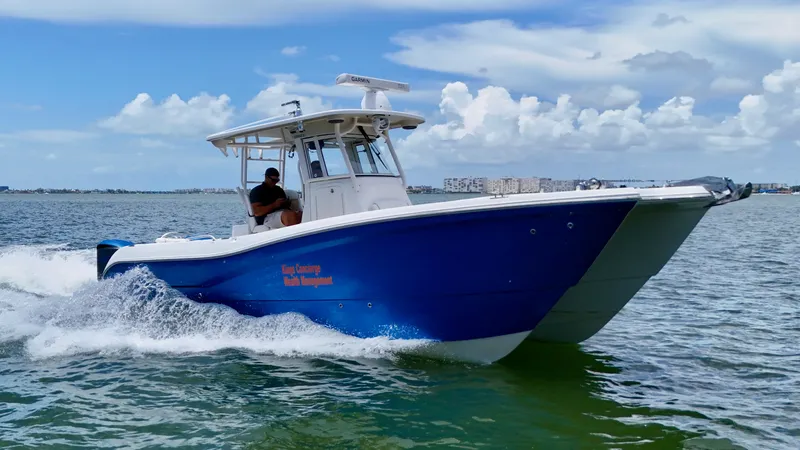 The Image of 2014 World Cat 295 CC boat cruising on open water under a partly cloudy sky. - 1