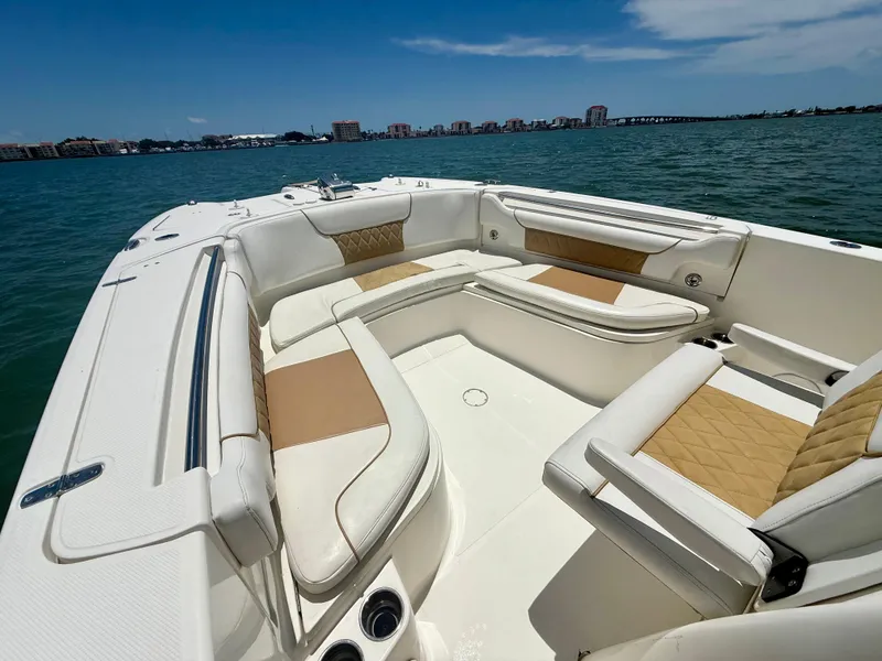 Slide: The Image of 2014 World Cat 295 CC boat interior with cushioned seating, on a sunny day. - 10