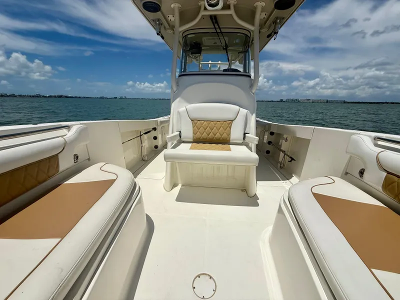 Slide: The Image of 2014 World Cat 295 CC boat interior with cushioned seating, ocean view, and blue sky. - 12