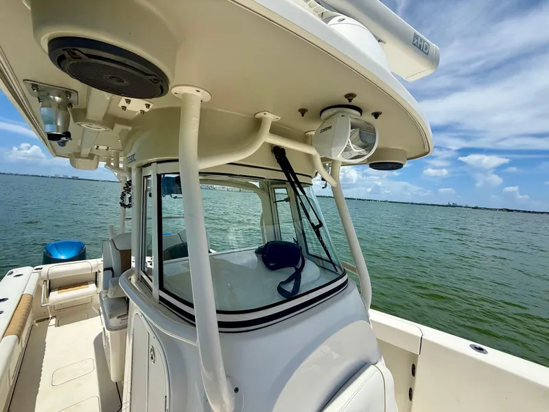 Slide: The Image of 2014 World Cat 295 CC boat on calm water under a clear blue sky. - 13