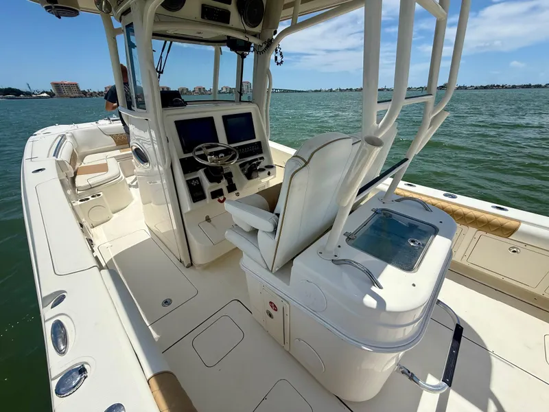 Slide: The Image of 2014 World Cat 295 CC boat interior with helm, seating, and ocean view. - 18