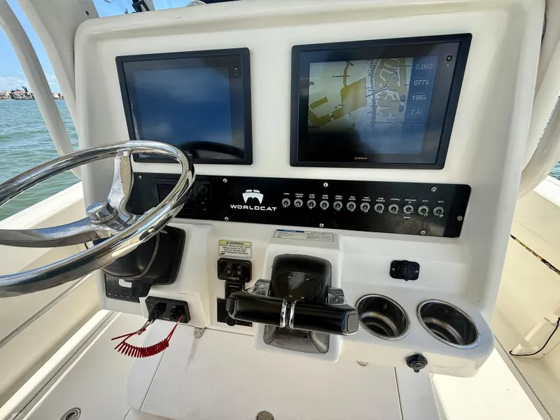 Slide: The Image of 2014 World Cat 295 CC boat dashboard with steering wheel and navigation screens. - 21