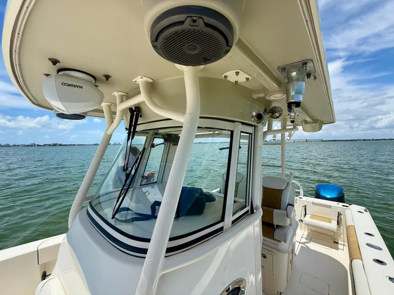 Slide: The Image of 2014 World Cat 295 CC boat on water, featuring a spacious deck and modern equipment. - 23