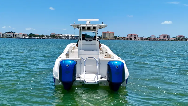 Slide: The Image of 2014 World Cat 295 CC boat on water, twin engines, cityscape background. - 6