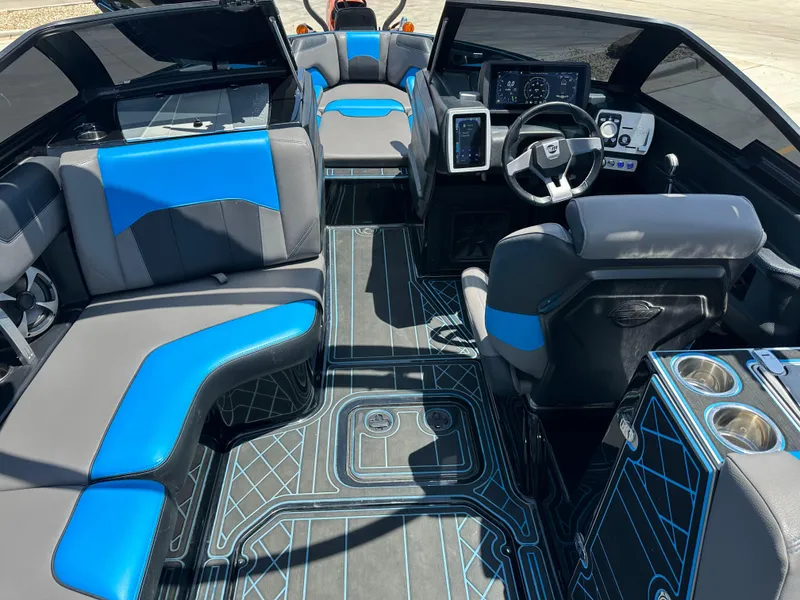Slide: The Image of 2020 Malibu Wakesetter 25 LSV interior with blue and gray seating, modern dashboard, and cup holders. - 16