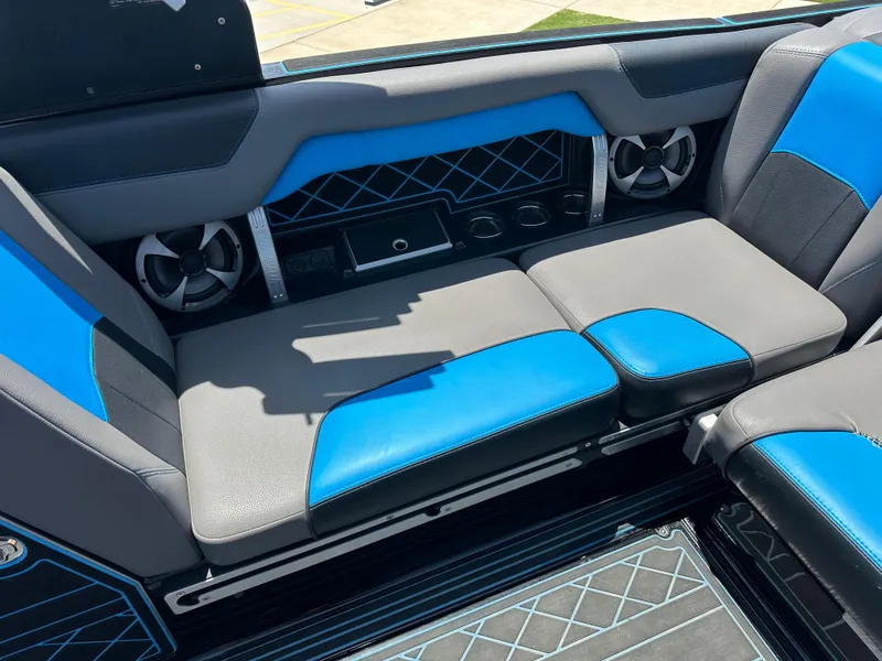 Slide: The Image of 2020 Malibu Wakesetter 25 LSV interior with blue and gray seating, featuring built-in speakers. - 18