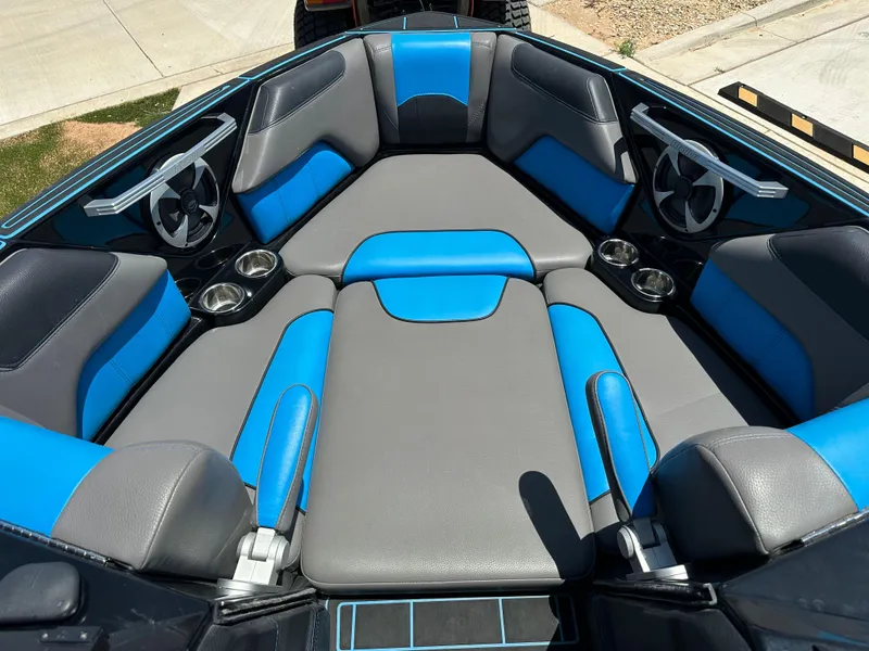 Slide: The Image of 2020 Malibu Wakesetter 25 LSV boat interior with blue and gray seating, cup holders, and speakers. - 19