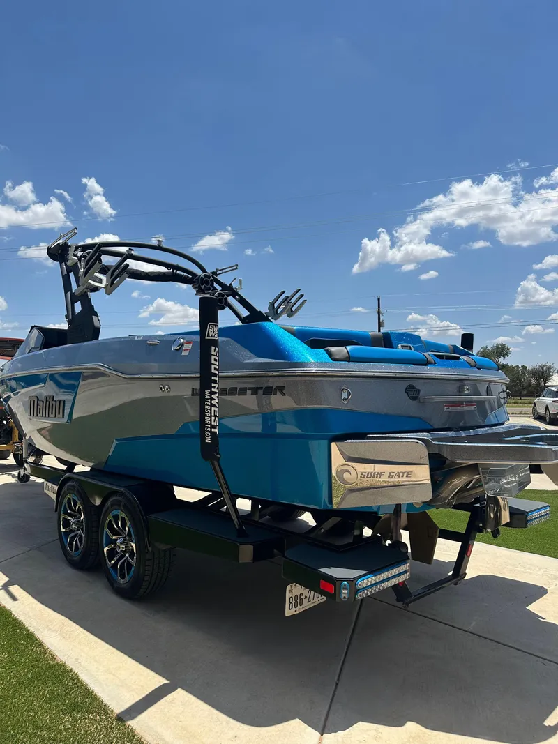 Slide: The Image of 2020 Malibu Wakesetter 25 LSV boat on trailer under clear blue sky. - 5