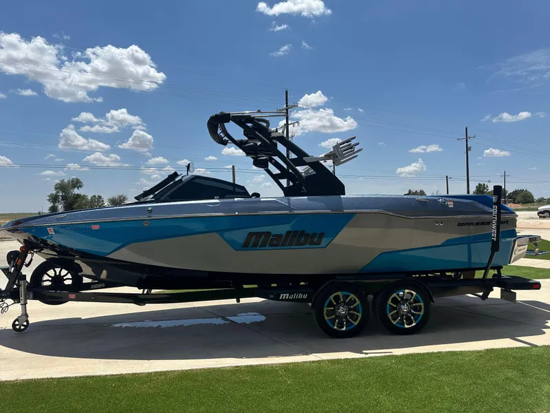 Slide: The Image of 2020 Malibu Wakesetter 25 LSV boat on trailer under clear blue sky. - 6