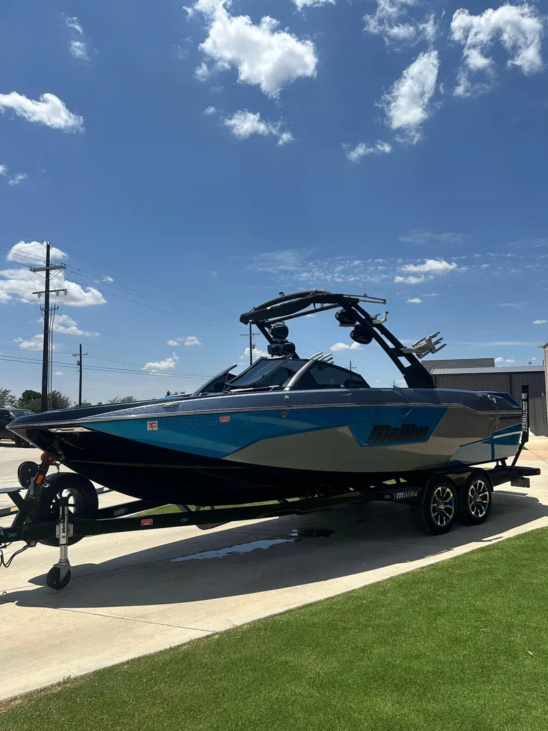 Slide: The Image of 2020 Malibu Wakesetter 25 LSV boat on trailer under clear blue sky. - 7
