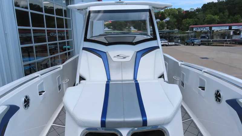 Slide: The Image of 2016 Sunsation 34 CCX boat with sleek white and blue seating, docked near a marina. - 19