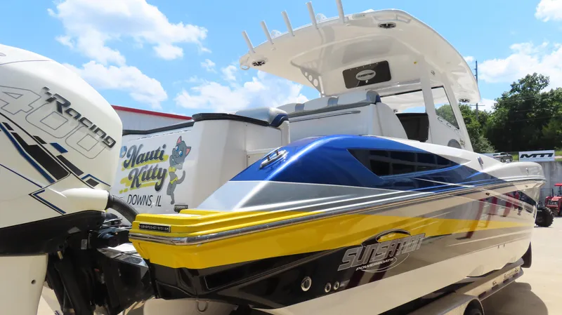 Slide: The Image of 2016 Sunsation 34 CCX powerboat with vibrant blue and yellow design, parked outdoors. - 5
