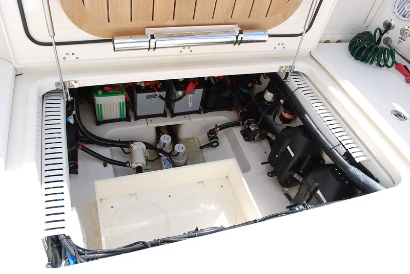Slide: The Image of 2017 Boston Whaler 330 Outrage engine compartment with batteries and wiring. - 24