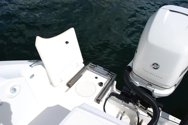 Slide: The Image of 2017 Boston Whaler 330 Outrage boat with open hatch and outboard motor on water. - 7