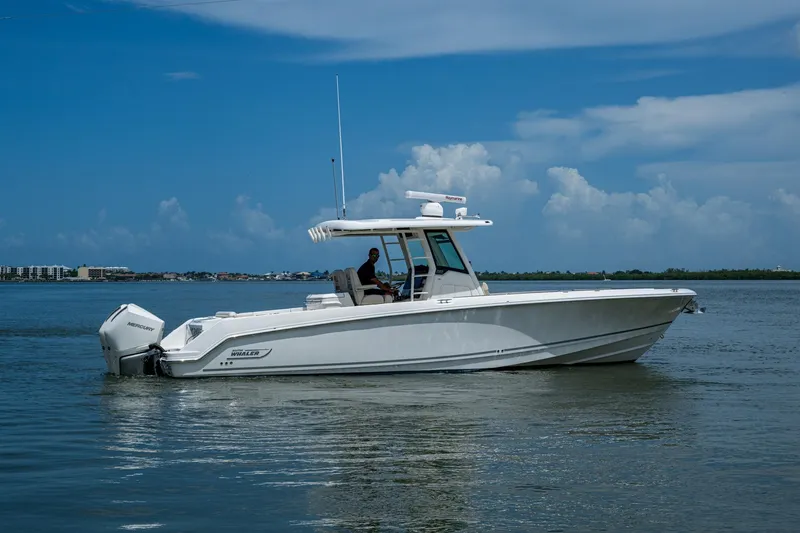 Slide: The Image of 2020 Boston Whaler 330 Outrage boat cruising on calm waters under a clear blue sky. - 0