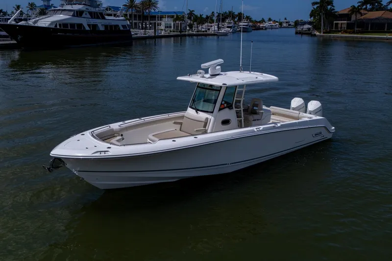 Slide: The Image of 2020 Boston Whaler 330 Outrage boat on calm water near marina. - 12